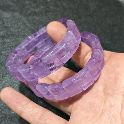 Close up view of stacked lavender amethyst bamboo segment bracelets highlighting translucent ice purple crystal texture