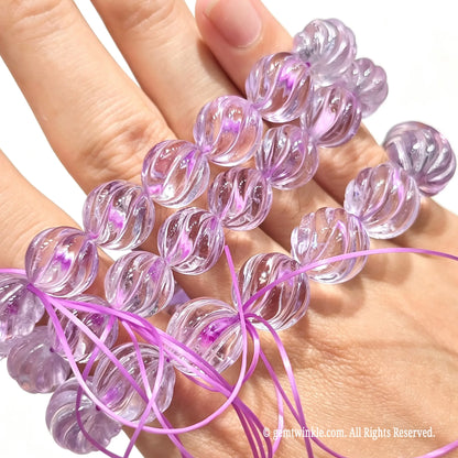 Light purple quartz carved spiral bead stretch bracelets worn across fingers showcasing smooth polish and light color