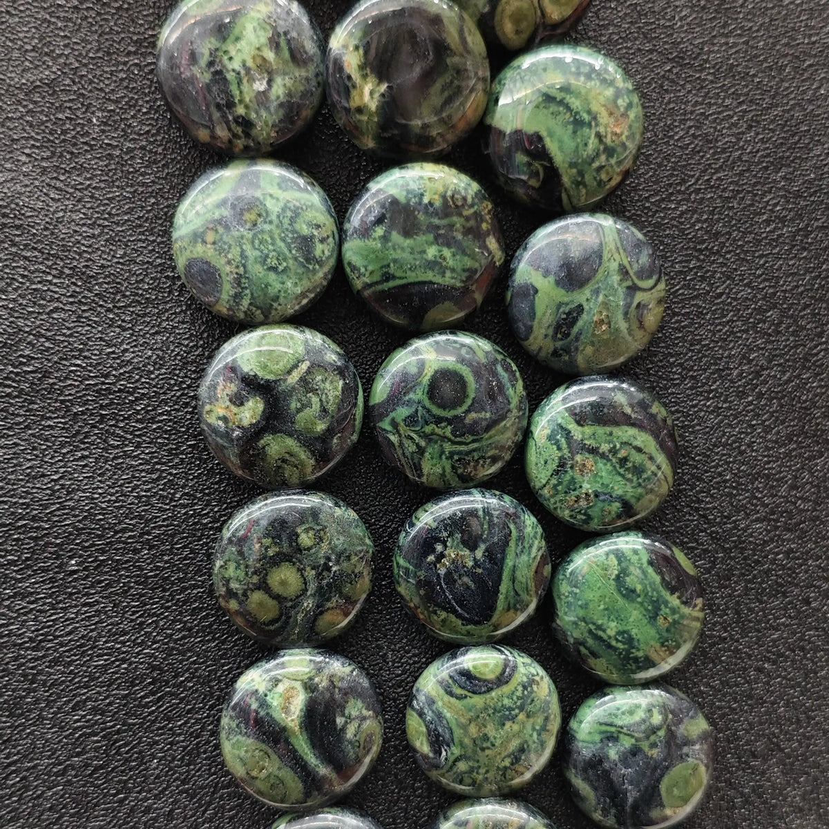 Strands of natural peacock eye stone smooth flat round coin beads displaying dark green orbicular patterns for DIY jewelry making