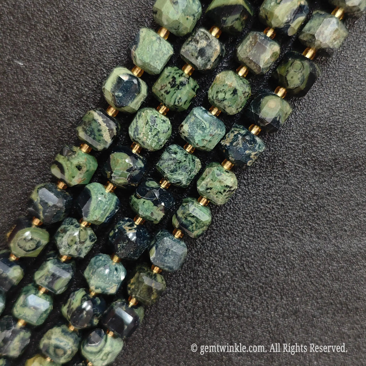 Multiple parallel strands of natural peacock eye stone soft-tumbled cube beads viewed from distance
