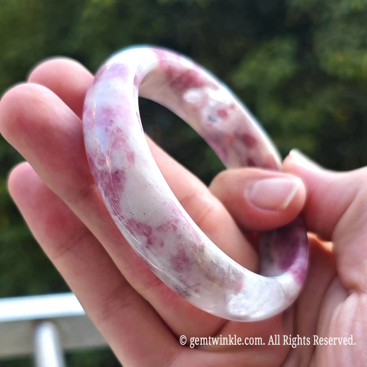Side view of plum blossom tourmaline gemstone bangle highlighting smooth polished rim and subtle translucent pattern
