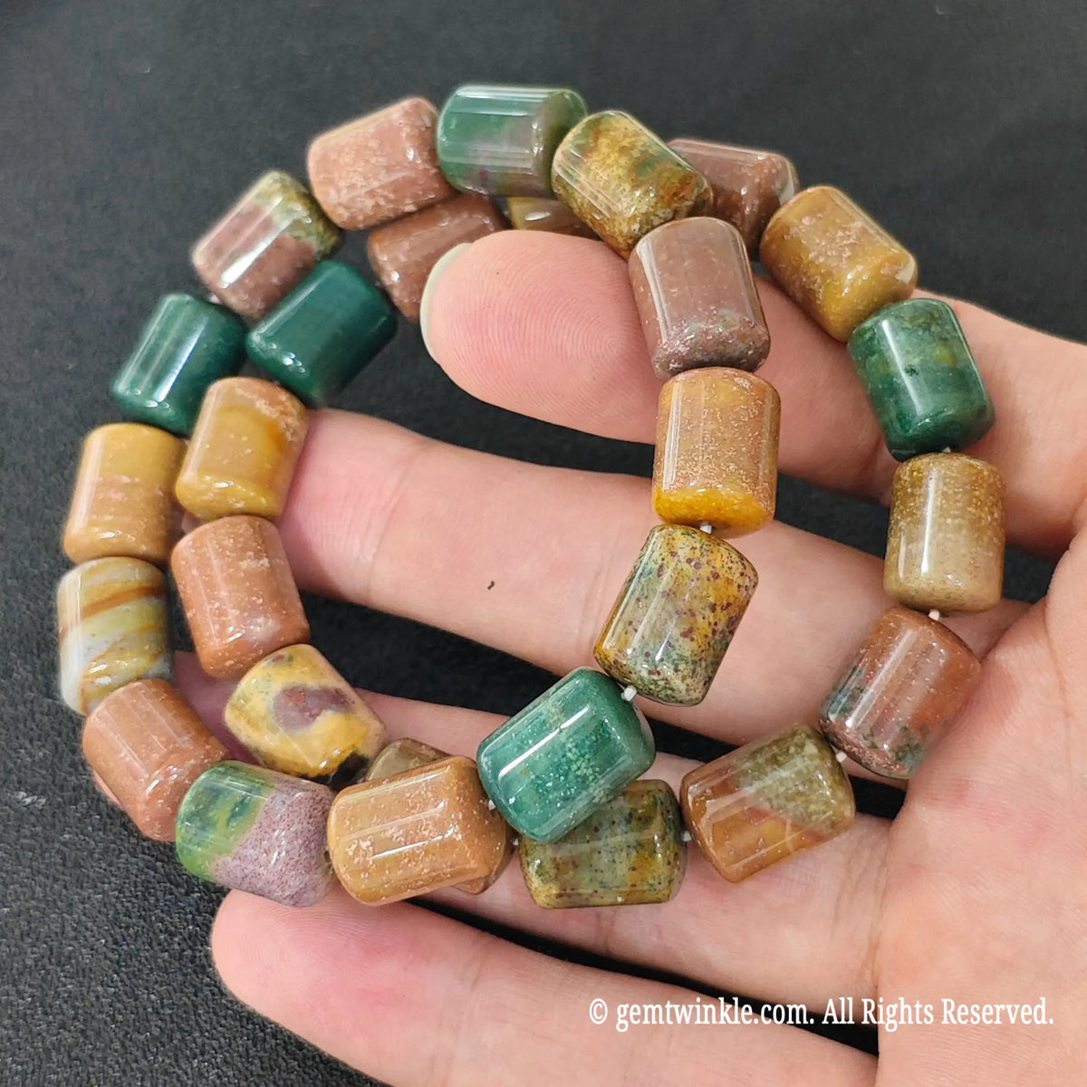 Polychrome Ocean Jasper Barrel Bead Strands Close Up on Hand