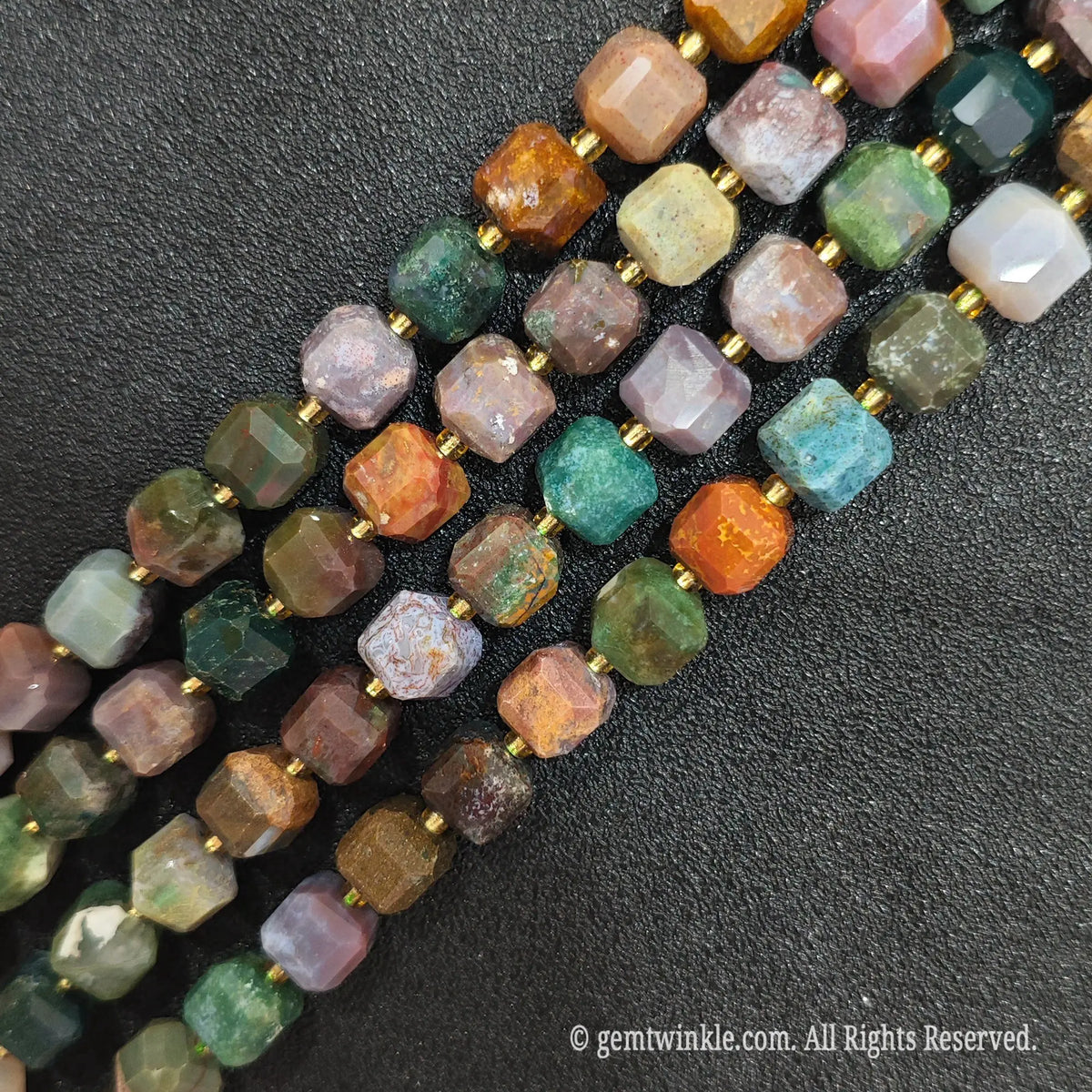 Multiple parallel strands of natural polychrome ocean jasper soft-tumbled cube beads viewed from distance[cite: 8]