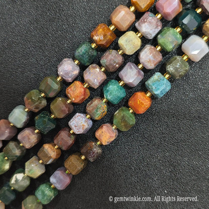 Multiple parallel strands of natural polychrome ocean jasper soft-tumbled cube beads viewed from distance[cite: 8]