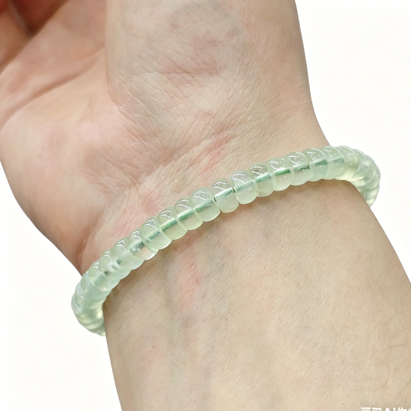 Soft apple green prehnite tablet bracelet worn on wrist; gentle luster and calming tone visible under natural light