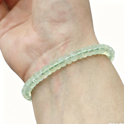Soft apple green prehnite tablet bracelet worn on wrist; gentle luster and calming tone visible under natural light