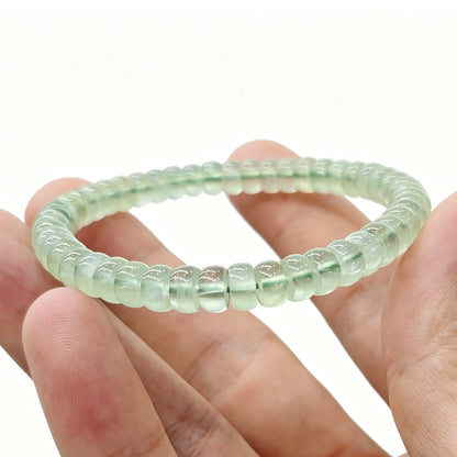 Close-up of mini prehnite tablet bracelet held in hand—showing translucency and smooth polished edges