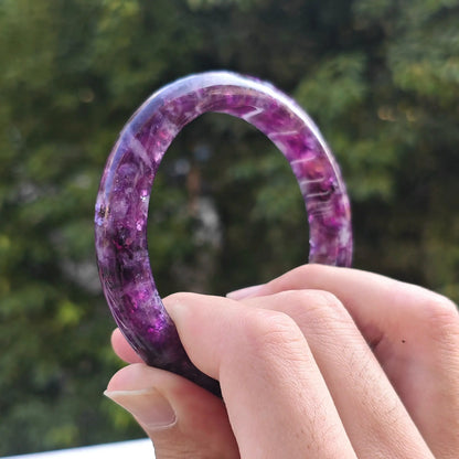Close up view of solid purple lepidolite crystal bangle displaying smooth comfortable inner curve