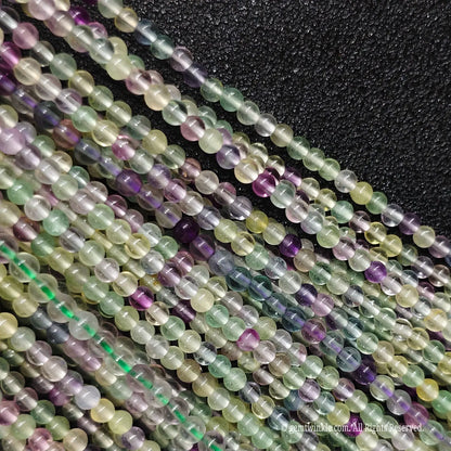 Delicate pastel green and purple micro fluorite gemstone beads showing natural mineral inclusions