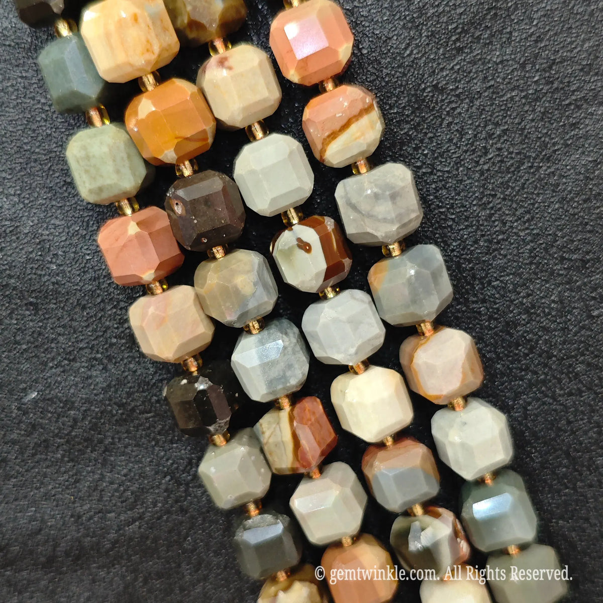 Multiple parallel strands of natural ocean jasper soft-tumbled cube beads viewed from distance