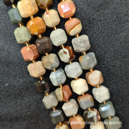 Multiple parallel strands of natural ocean jasper soft-tumbled cube beads viewed from distance