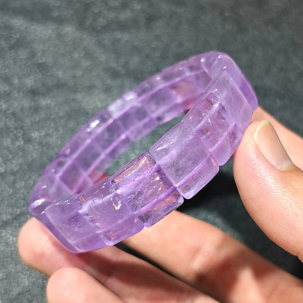 Natural lavender amethyst translucent bamboo segment stretch bracelet held on hand displaying purple ice clarity