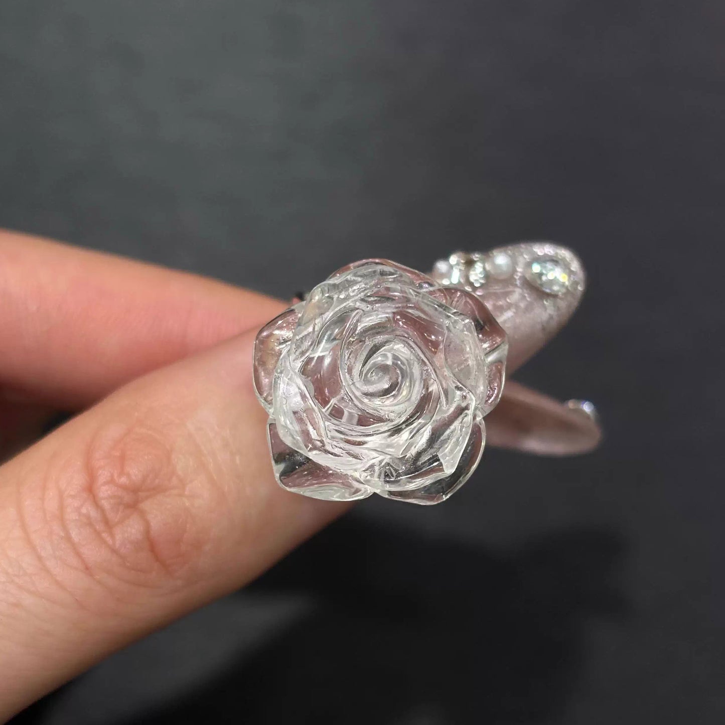 Side view of clear quartz rose ring on finger, highlighting 3D carved depth and smooth silver band