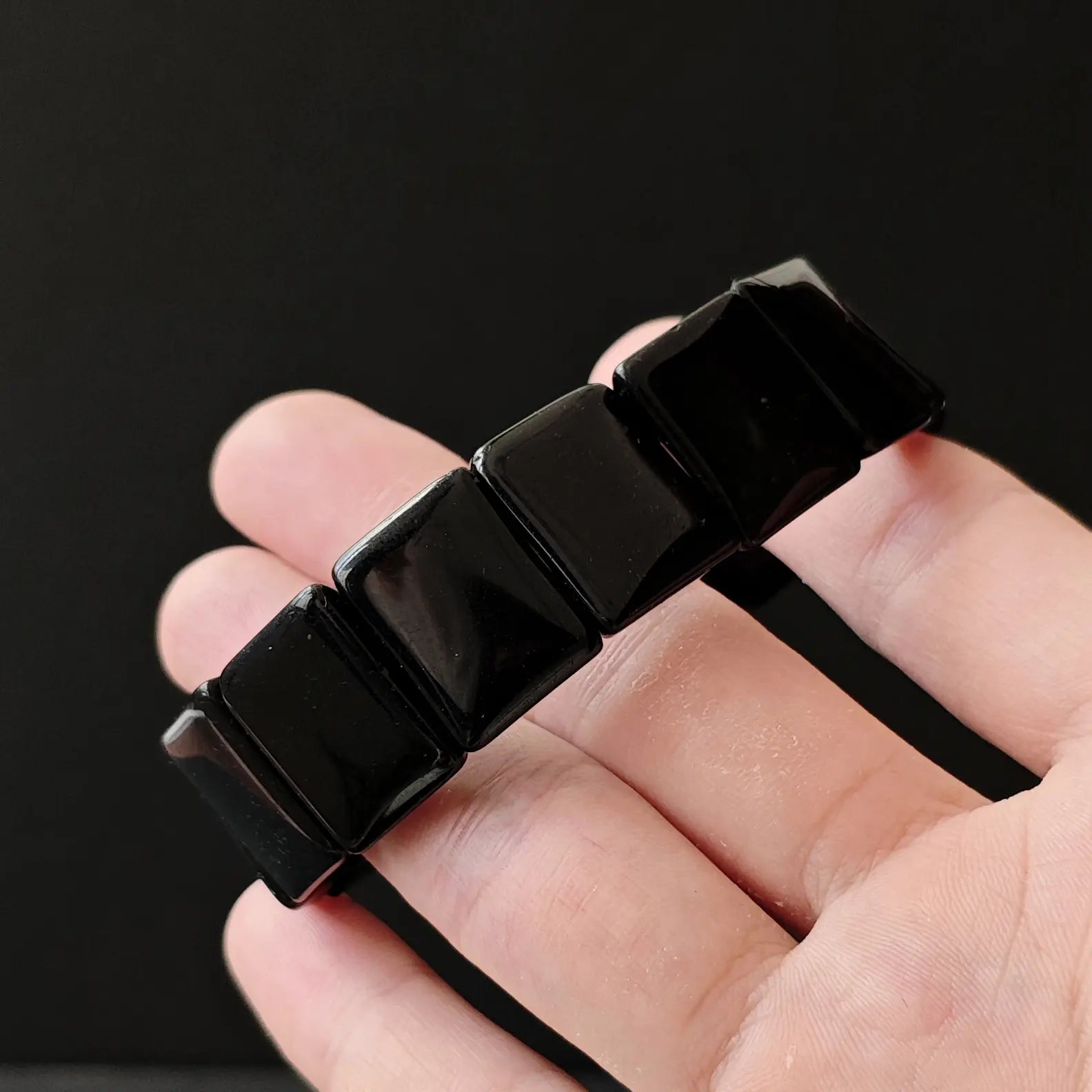 Side view of black obsidian square bead handchain highlighting precise alignment and seamless joints