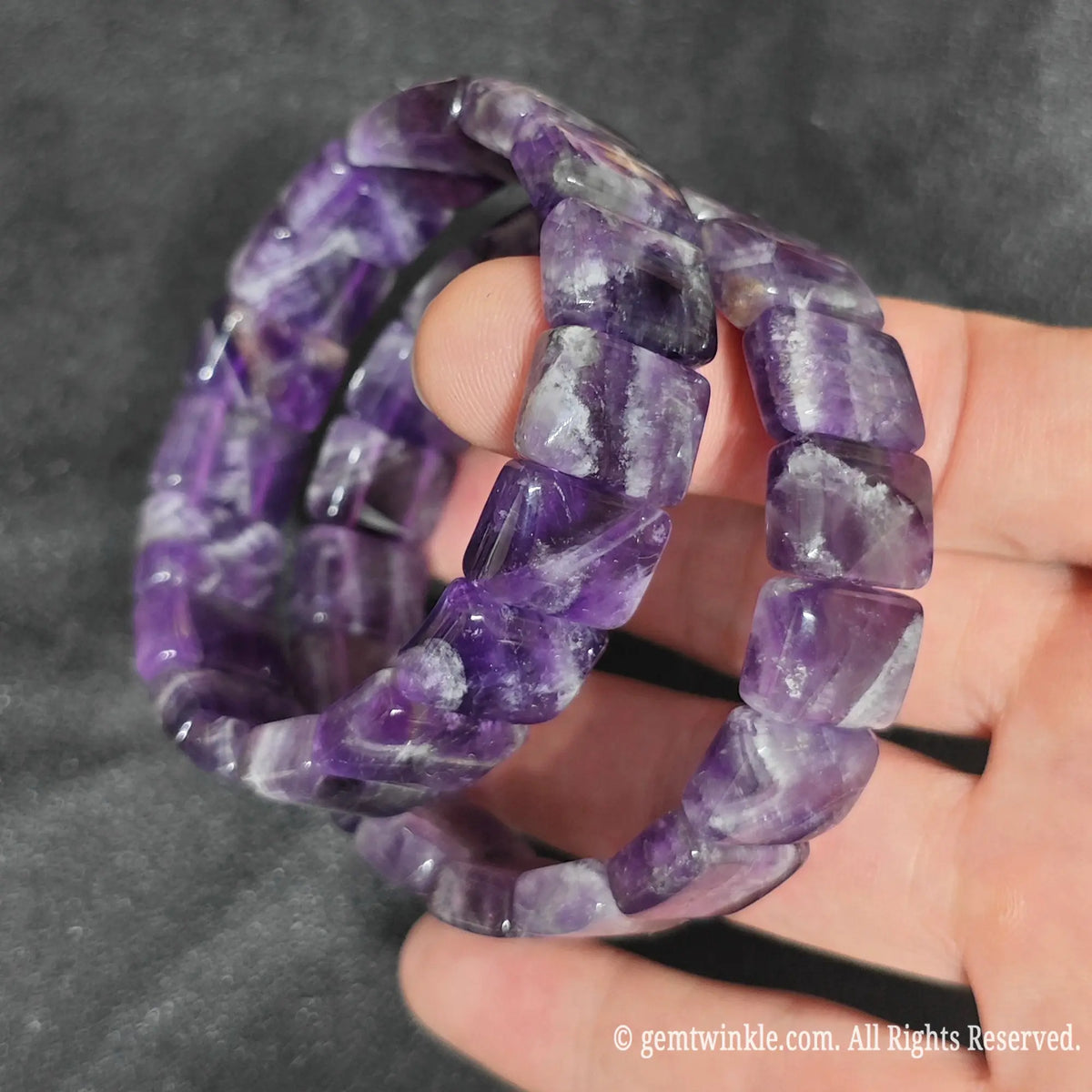 Hand displaying a deep velvet chevron amethyst smooth bamboo segment stretch bracelet highlighting midnight purple tones