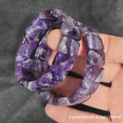 Hand displaying a deep velvet chevron amethyst smooth bamboo segment stretch bracelet highlighting midnight purple tones