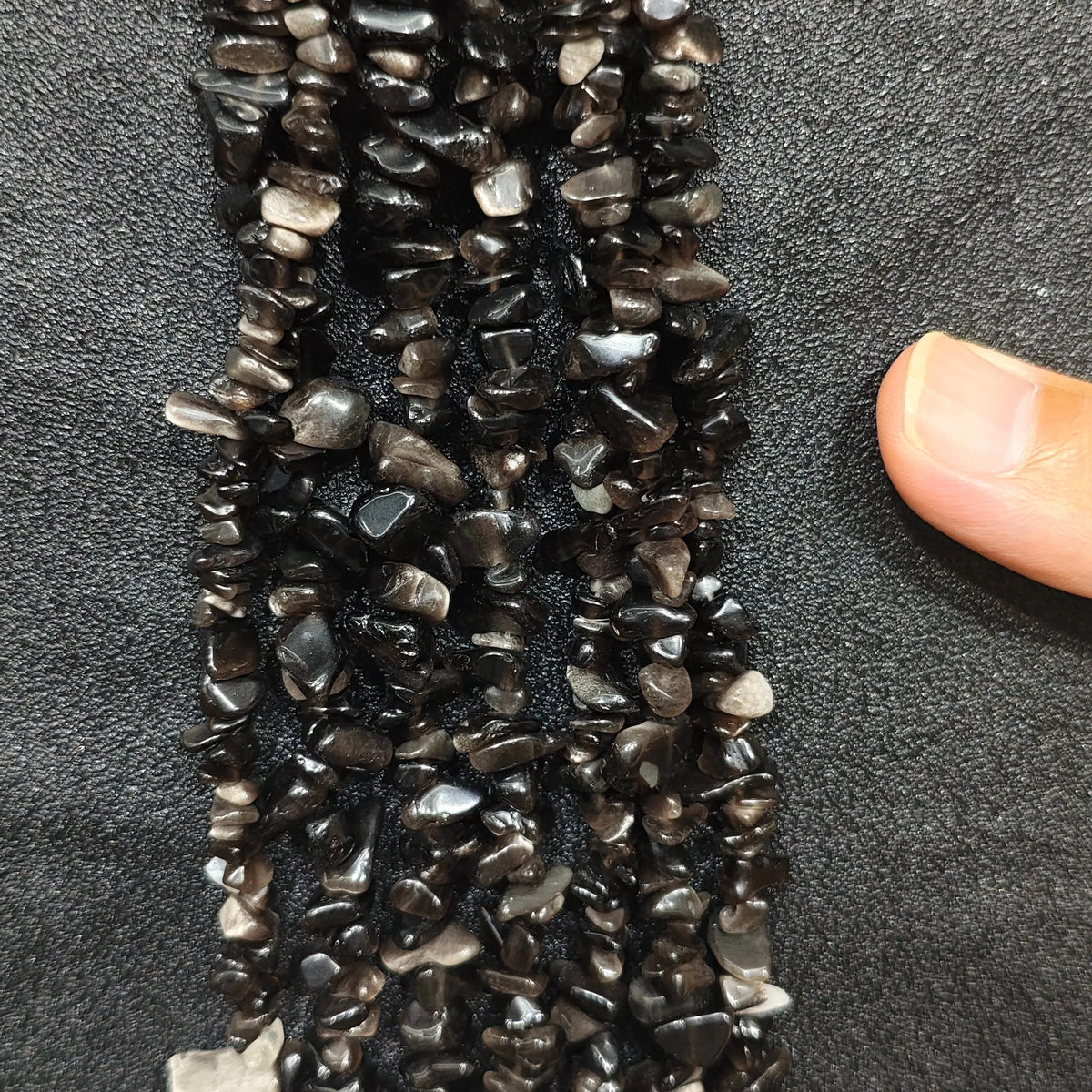 Close up of multi strands of natural silver sheen obsidian 5-10mm irregular black and silver chips