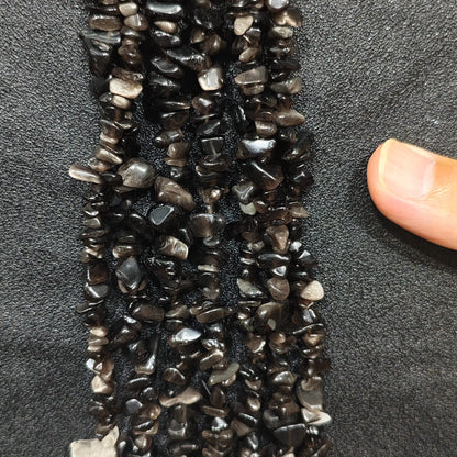 Close up of multi strands of natural silver sheen obsidian 5-10mm irregular black and silver chips