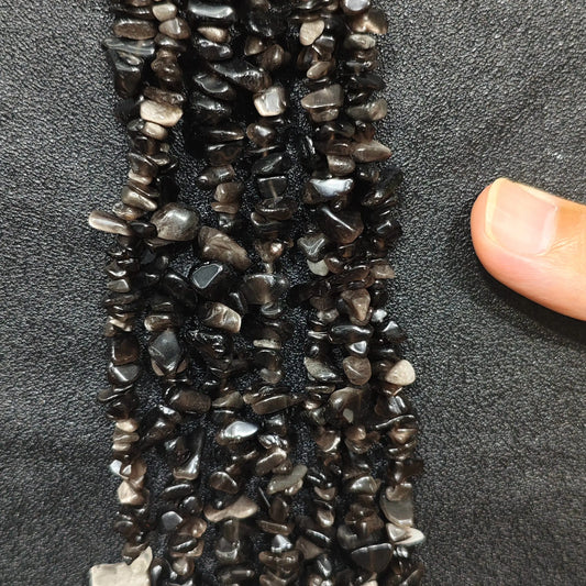 Close up of multi strands of natural silver sheen obsidian 5-10mm irregular black and silver chips