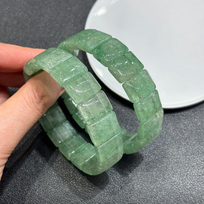 Two natural green strawberry quartz tablet bead bracelets layered on hand; showcases precise square cuts and organic cloud patterns
