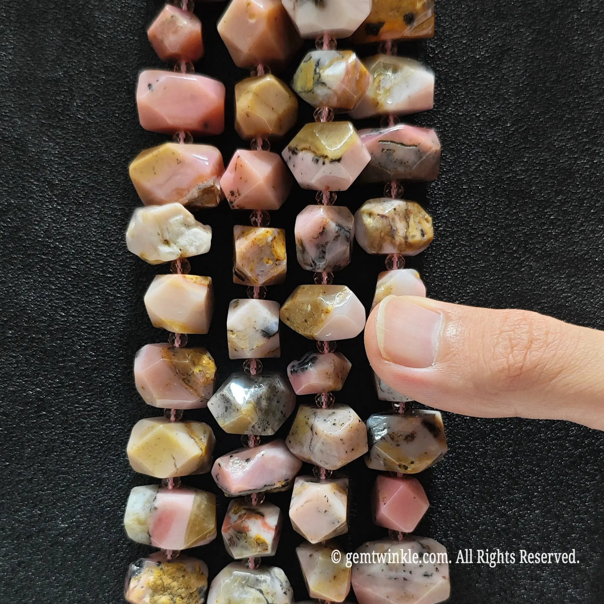 Side view of natural pink opal faceted nugget beads strung on loose strands displaying multi tone matrix