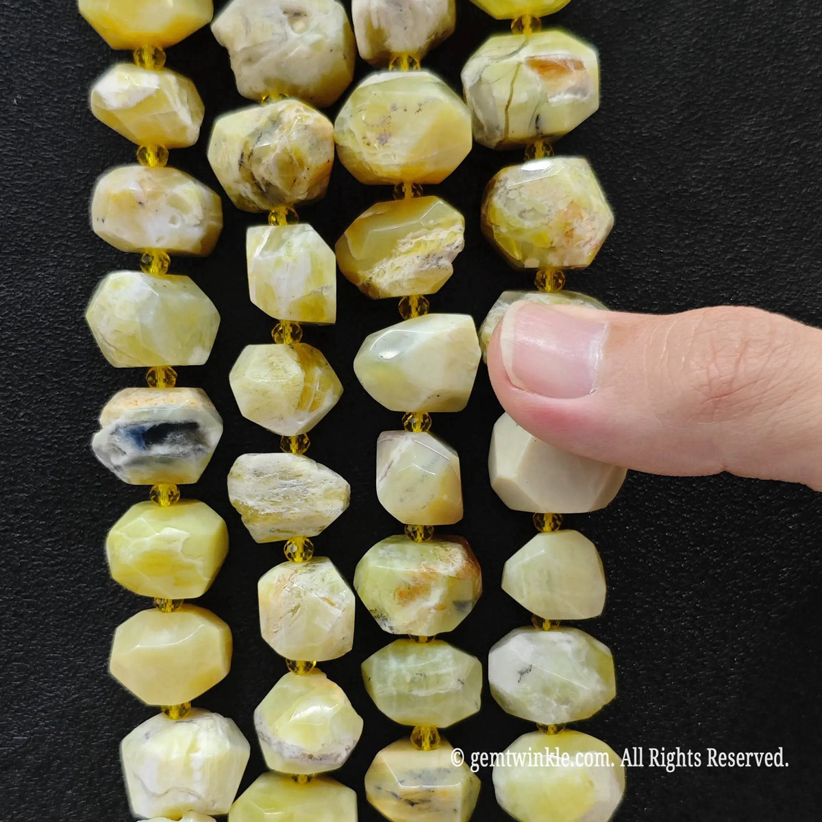 Side view of natural yellow opal faceted nugget beads strung on loose strands displaying sunny ochre matrix