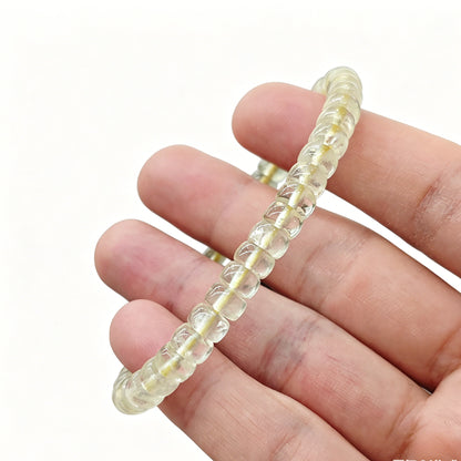 Gentle touch on lemon citrine tablet bead—revealing smooth finish, subtle internal texture, and luminous light-yellow color