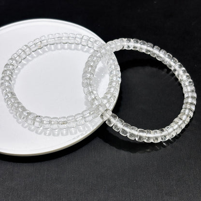 Two transparent clear quartz disc bead bracelets stacked on black background, modern layering style