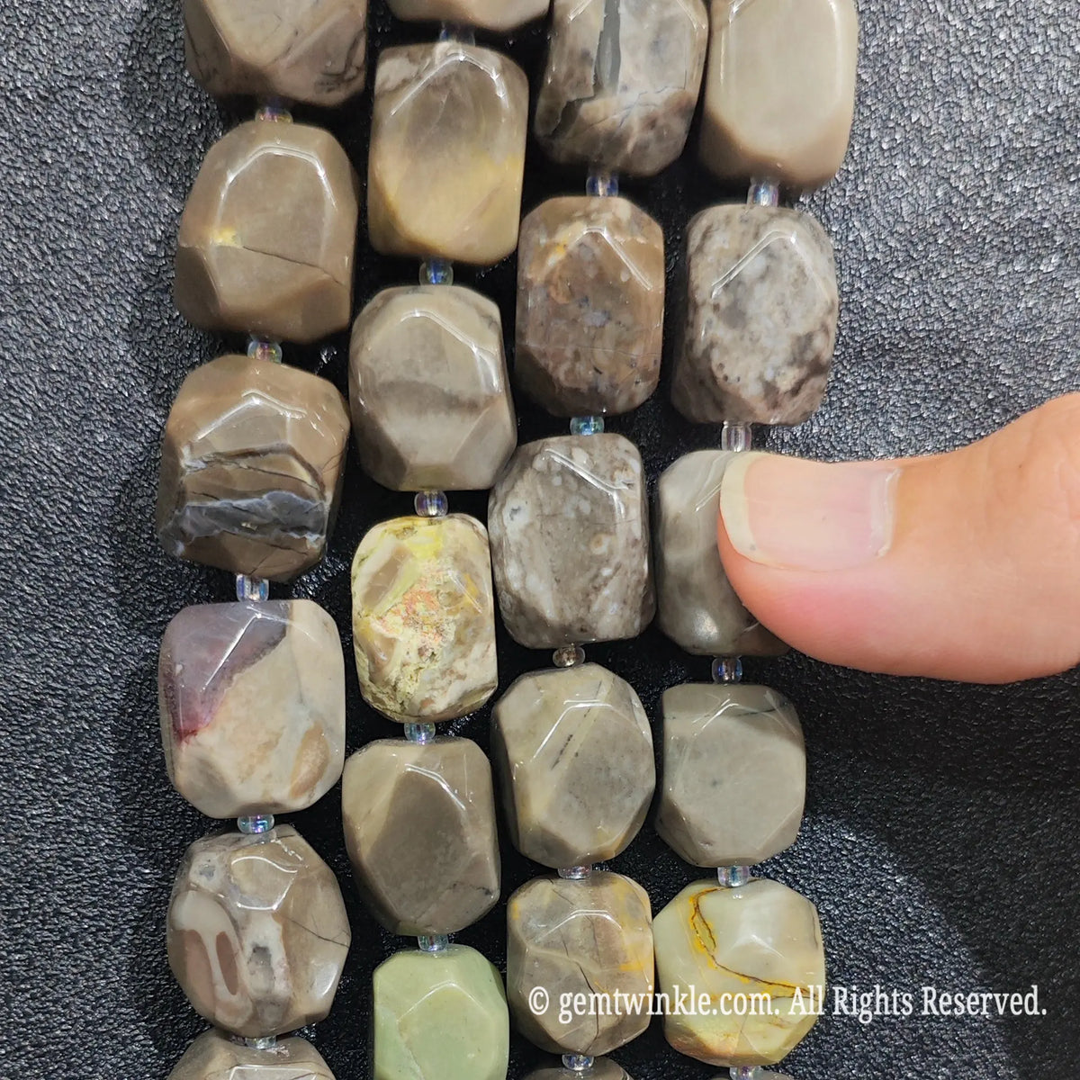 Close up view of natural volcanic ash agate nugget beads showcasing smooth polished finish and center drilled hole