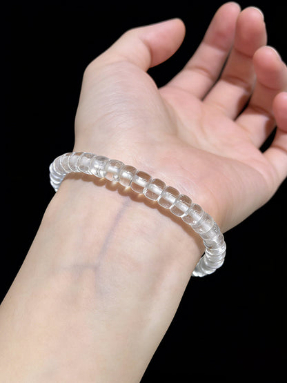 Woman wearing transparent clear quartz disc bead bracelet on wrist, minimalist crystal jewelry for daily wear