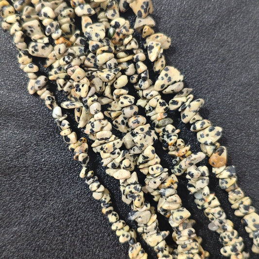Multiple strands of natural darmatian jasper 5-10mm irregular chip beads showing cream and black spotted texture[cite: 8]