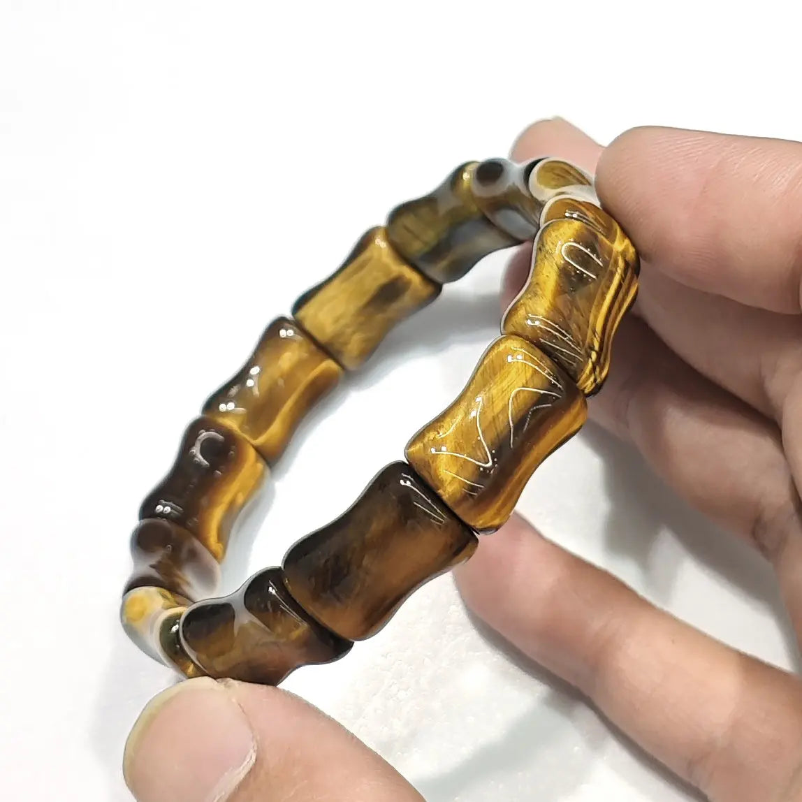 Close-up of women's golden tiger eye bamboo bracelet with 15mm segment beads, warm honey tones and silky chatoyancy