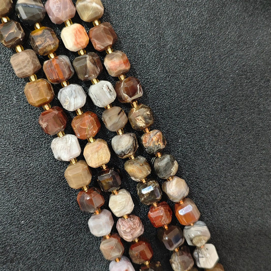 Close up of multi strands of natural wood grain jasper soft-tumbled geometric cube beads showing overall strand layout