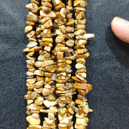 Close up of multi strands of natural wood grain stone 5-10mm irregular banded brown chips