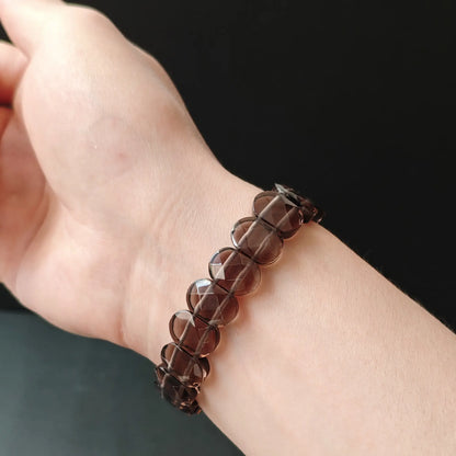 Woman wearing natural ice obsidian oval bead bracelet, elegant minimalist spiritual accessory for office, yoga, or self-care routines; lightweight and comfortable
