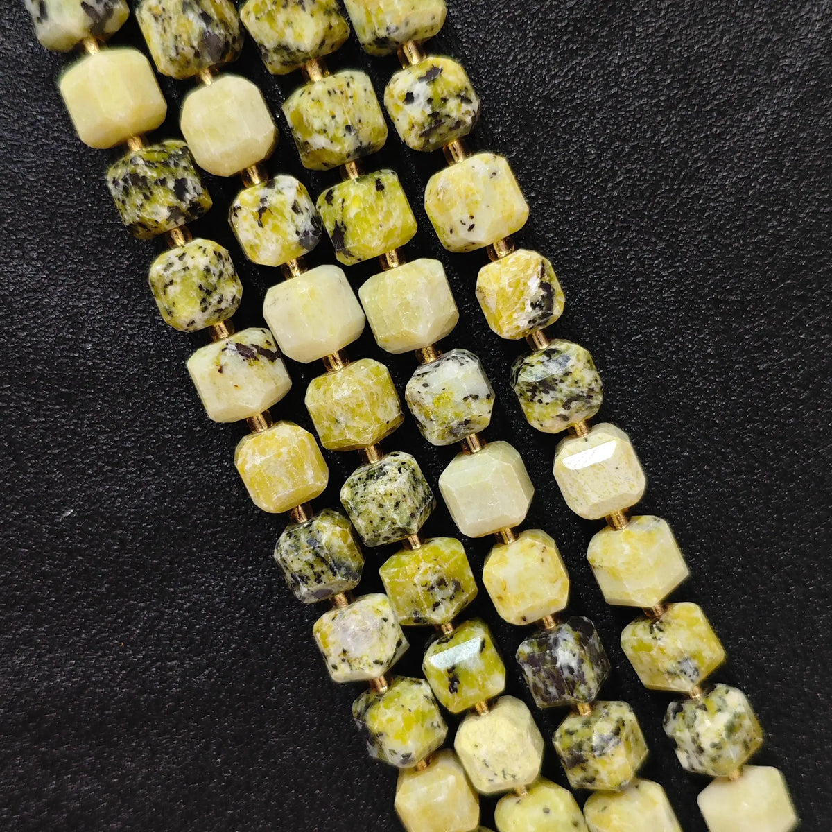 Close up of multi strands of natural yellow jasper soft-tumbled geometric cube beads showing overall strand layout