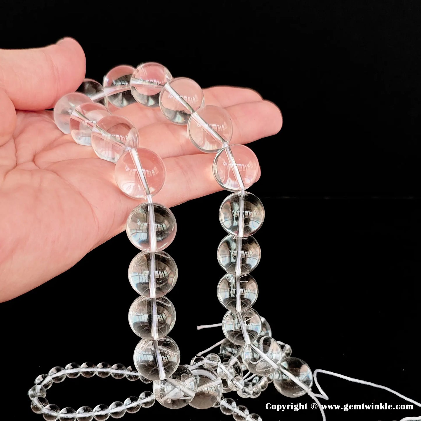 Micro closeup of AA eye-clean clear quartz crystal round beads showing flawless transparency and no internal ice cracks