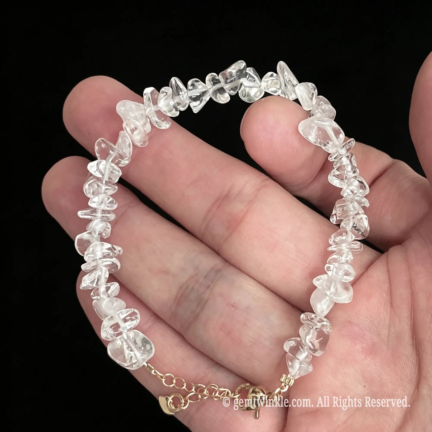 adjustable clear quartz chip bracelet held on hand showcasing 15cm to 18cm sizing
