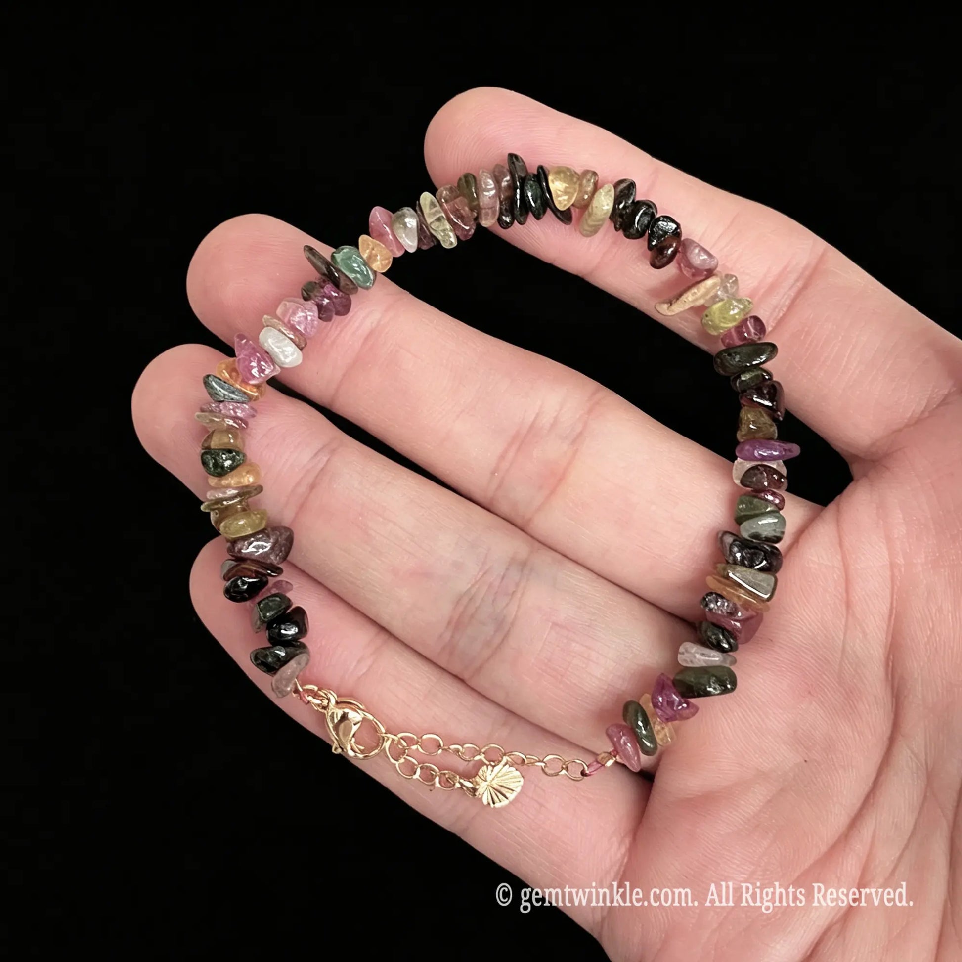 adjustable tourmaline chip bracelet in hand showing 15cm to 18cm flexible sizing