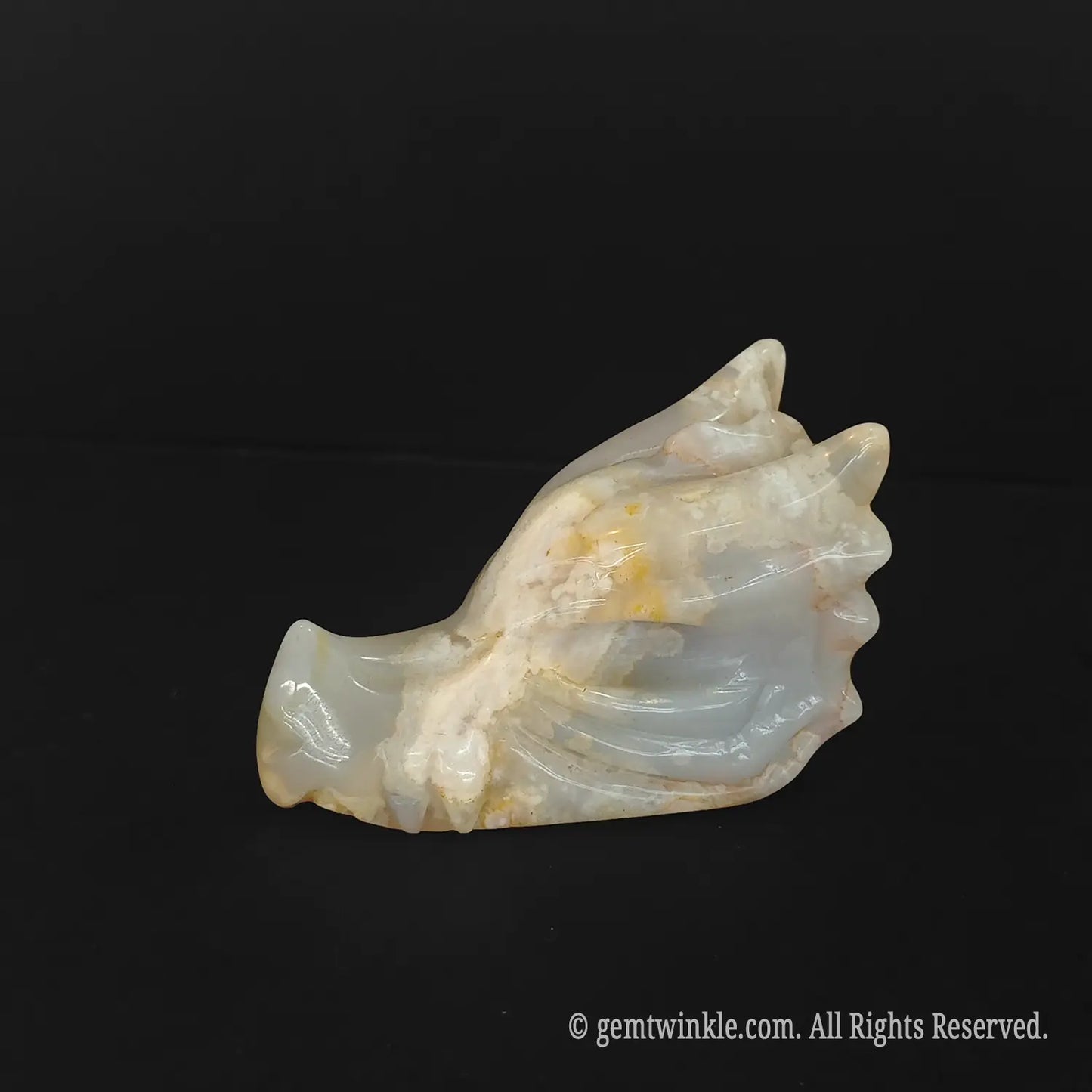 A standalone natural flower agate dragon head carving showcasing unique cream and grey chalcedony mineral patterns