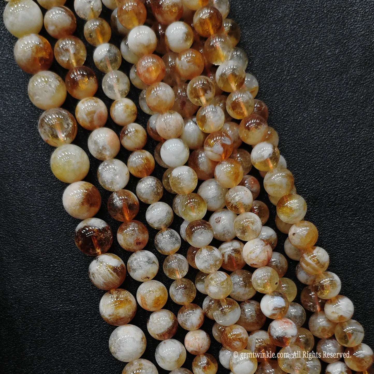 Four parallel rows of budget tier honey amber citrine loose strands showing distinct internal crystal fractures
