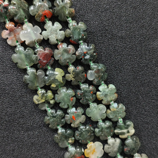 Macro closeup of African bloodstone plum blossom carved beads 15mm showing green base and red flecks