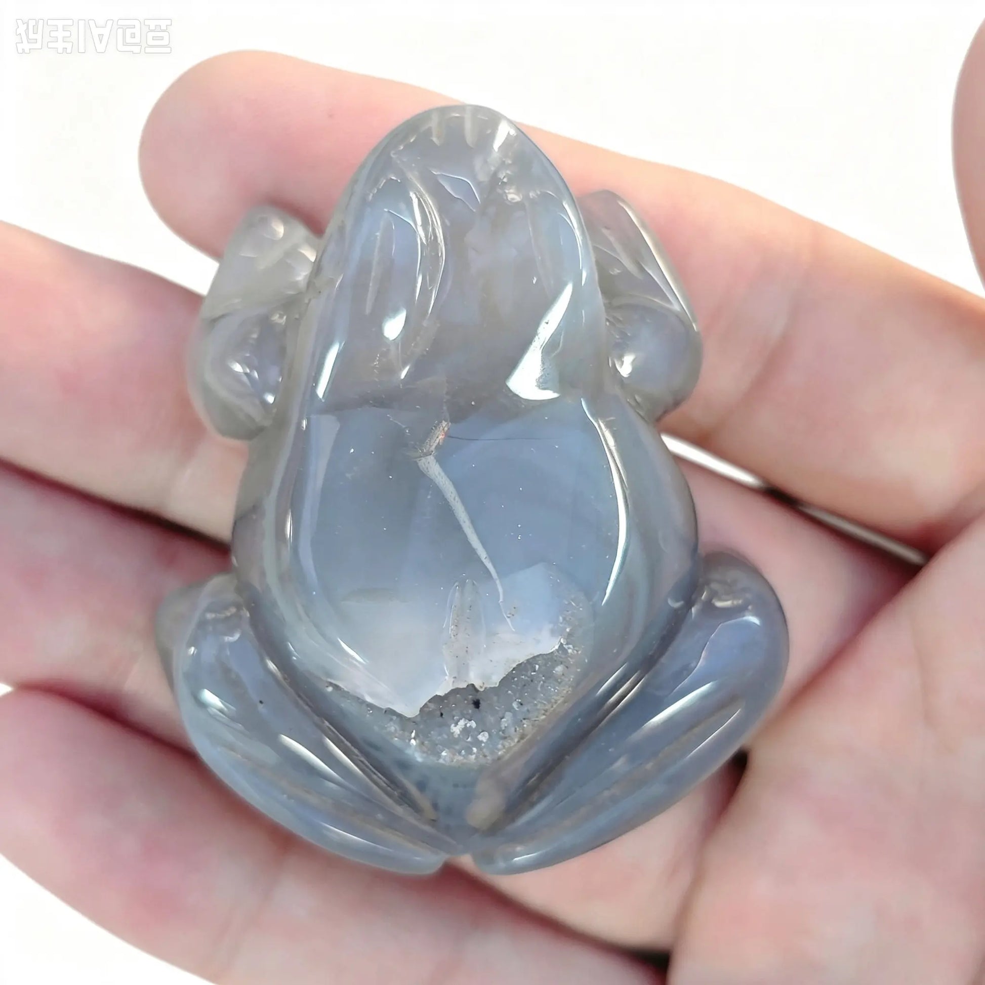 Agate geode frog figurine held in hand showing smooth grey body and subtle druzy cavity on back