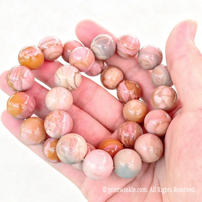 High clarity perspective of Alashan crackle agate stretch bracelets resting across fingers showing unique natural banding patterns