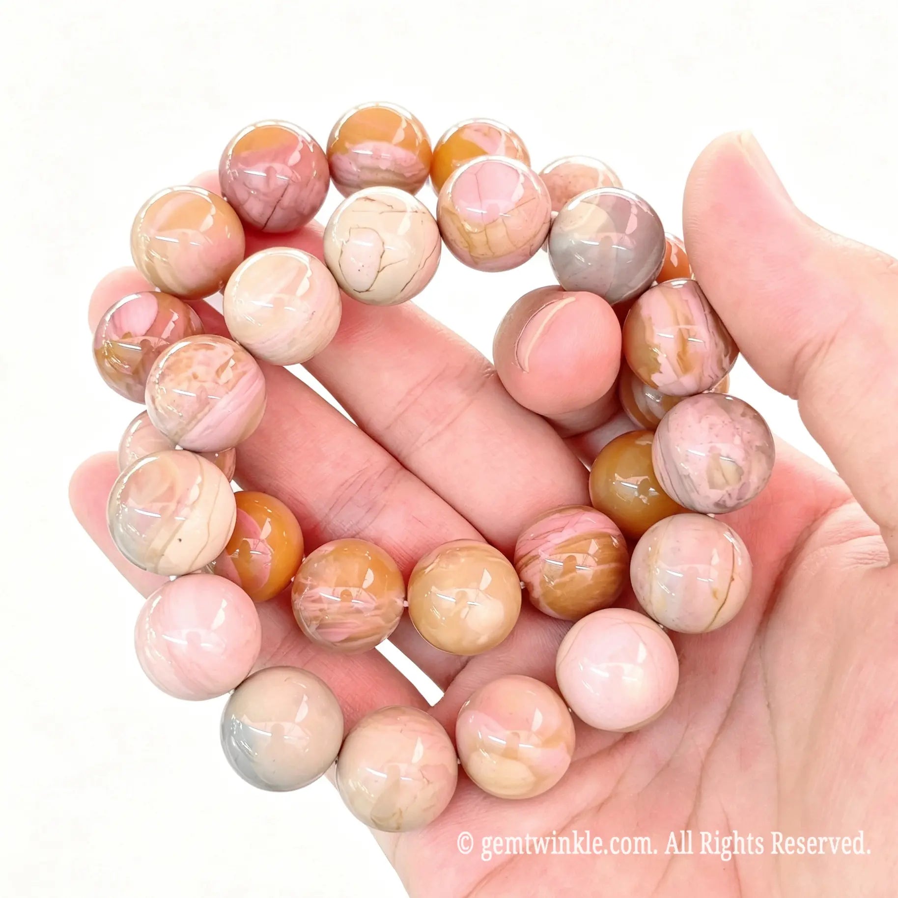 Alashan crackle agate round bead stretch bracelets arranged in a loop resting on open hand displaying natural weathered veins