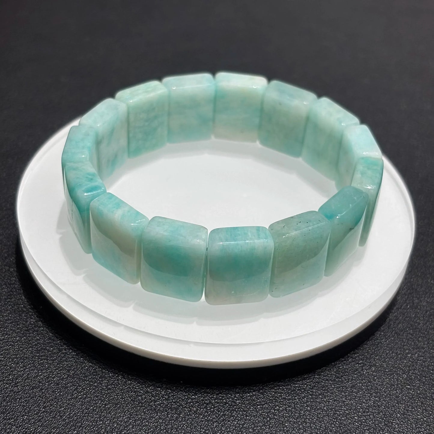 Stackable Amazonite Bangle Bracelets on a white plate, demonstrating how the bracelets look when worn together.