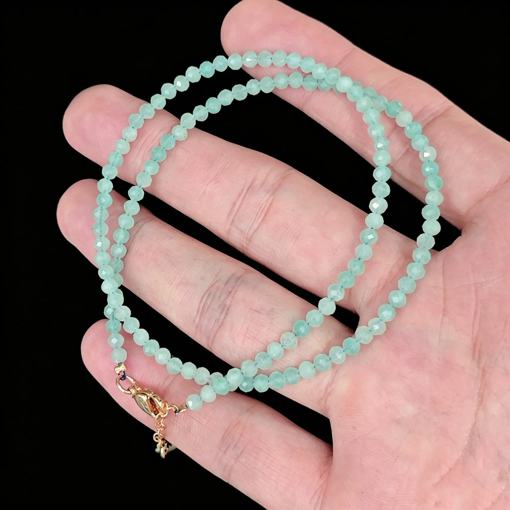 3-4mm amazonite faceted bead necklace coiled in hand showing turquoise green luster