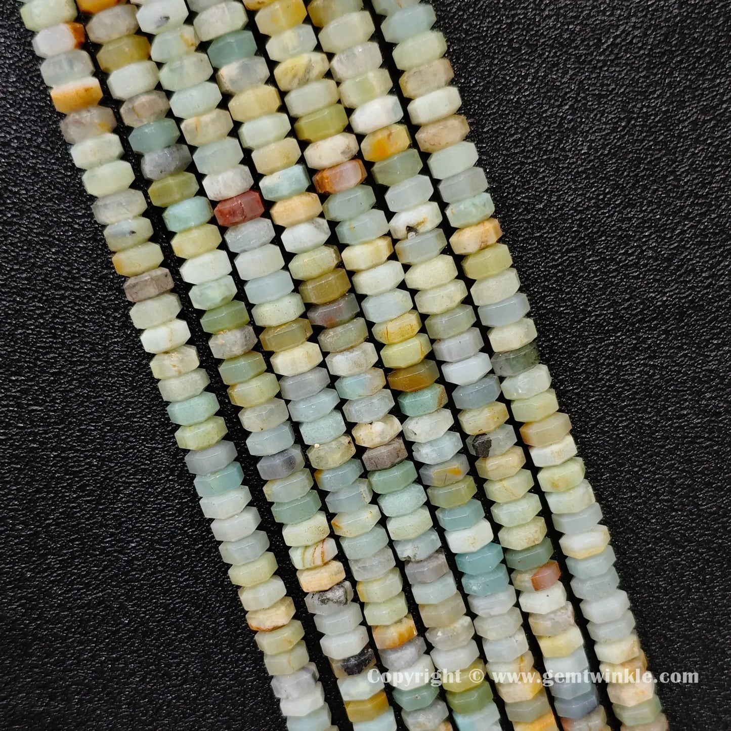 Perspective view of amazonite faceted heishi spacer beads showing uniform 3mm disc thickness