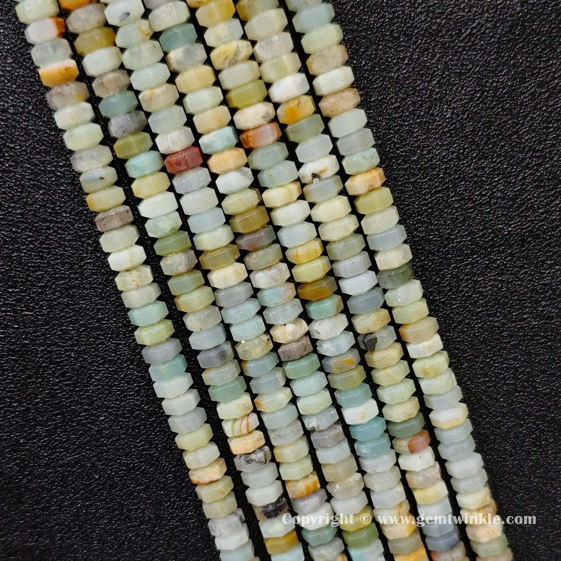 Perspective view of amazonite faceted heishi spacer beads showing uniform 3mm disc thickness