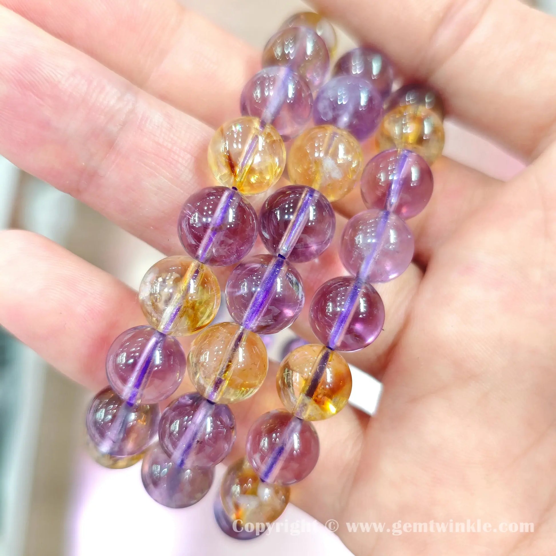 Top view of B+ grade 10mm purple amethyst and golden citrine round beads on elastic cord